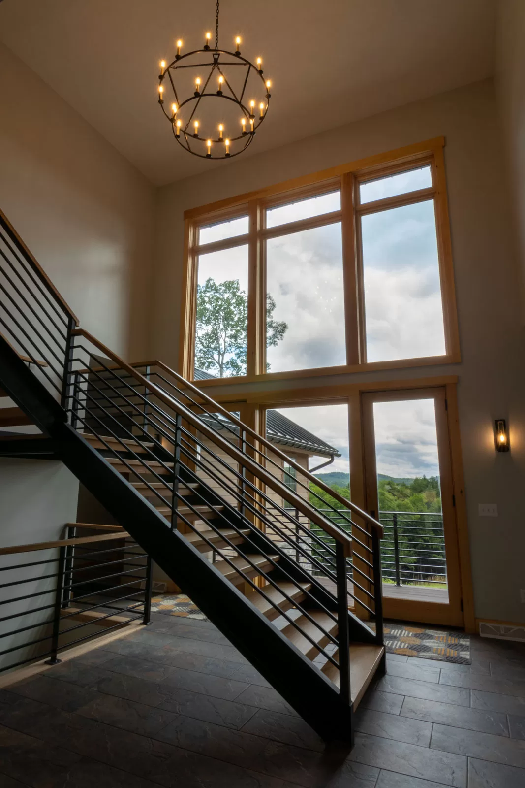 Adirondack residential family ski lodge entrance two-story windows. 